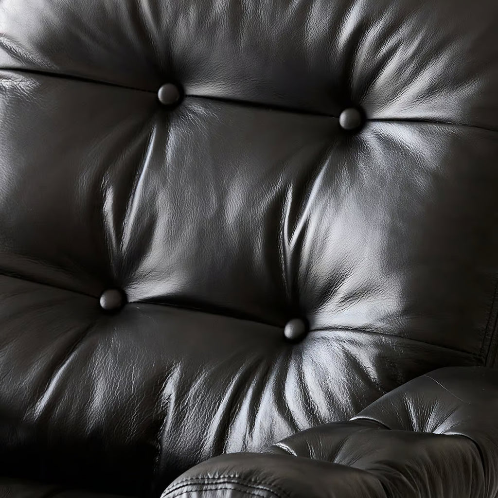 Close up of the tufted leather chair back, buttons drawn into the oil wax grain