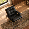 Leather accent chair on a rug in afternoon light, seen from above with the tufted seat in view
