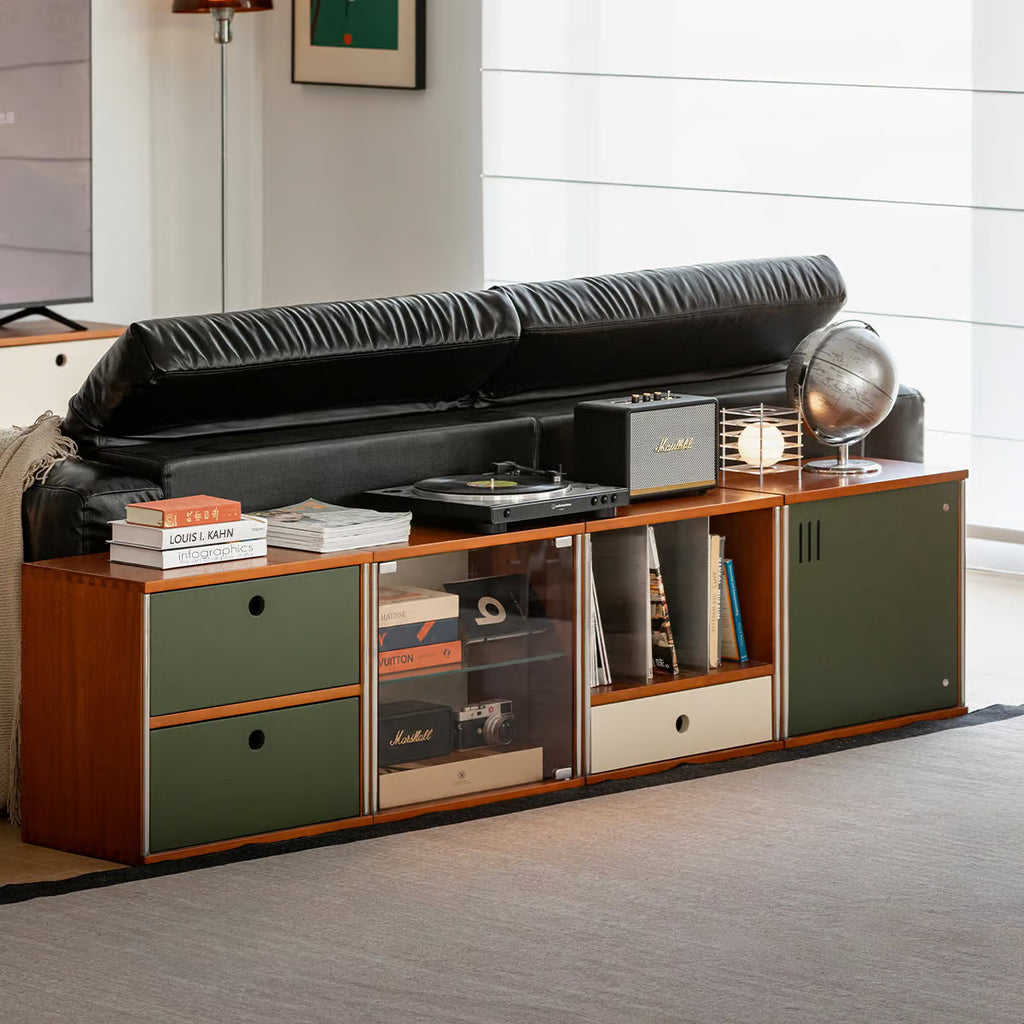 Long low modular console behind a leather sofa holding a turntable and upright vinyl records