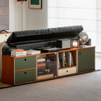 Long low modular console behind a leather sofa holding a turntable and upright vinyl records