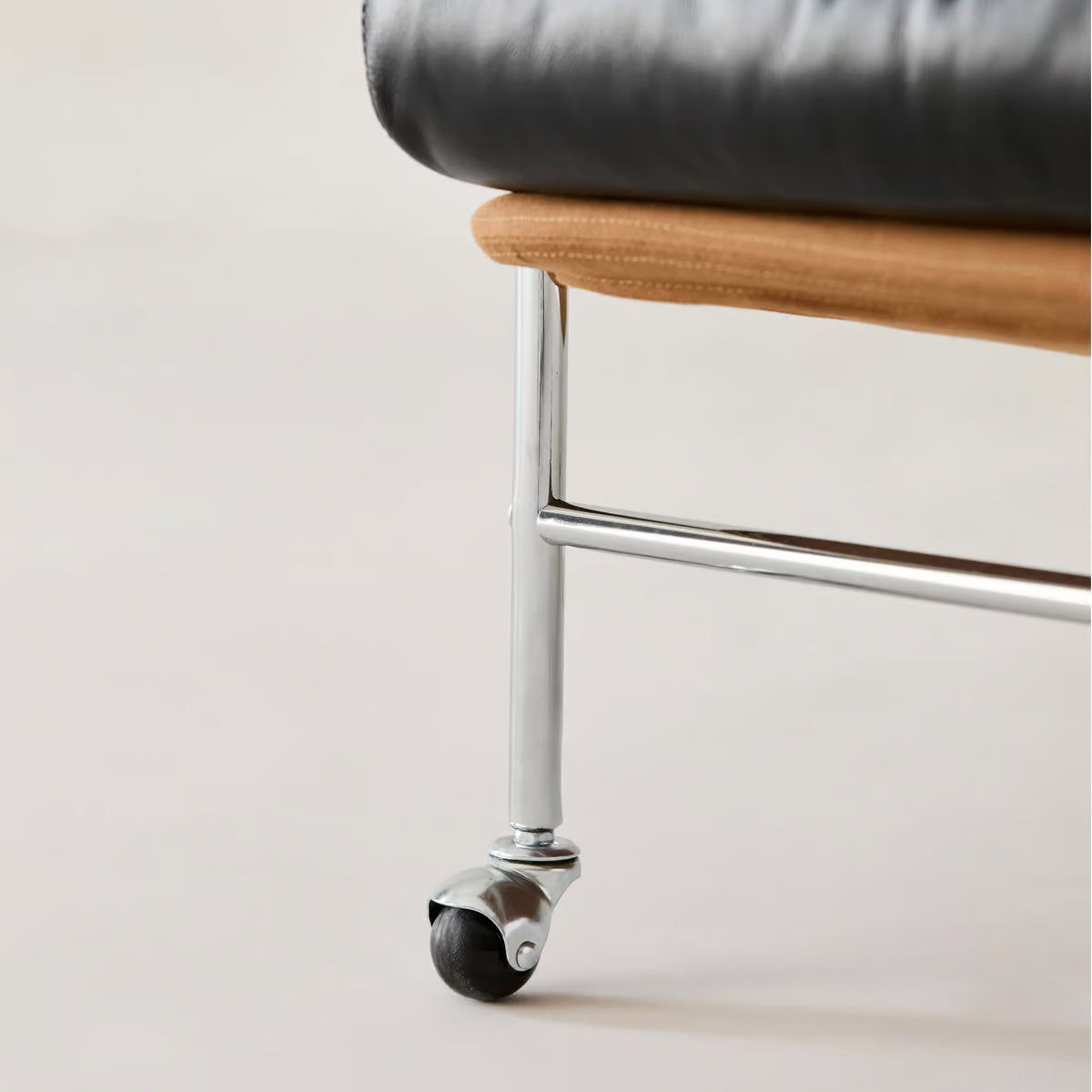 Swivel caster under the stainless steel leg of the rolling accent chair