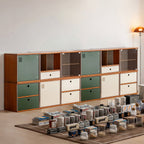 Two tier modular storage wall of twelve cabinets with glass, door and drawer fronts along one wall