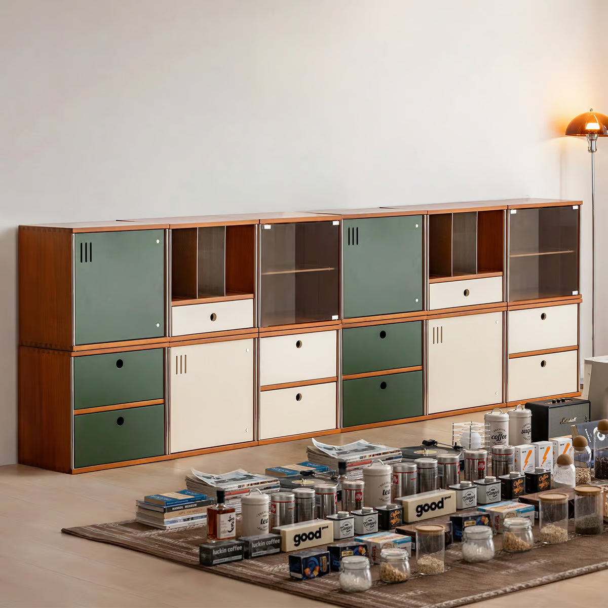 Two tier modular storage wall of twelve cabinets with glass, door and drawer fronts along one wall
